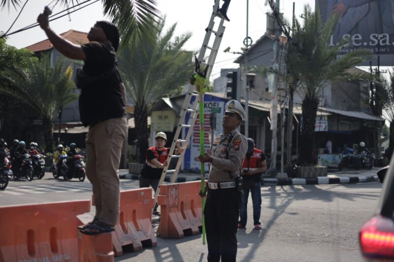 Satlantas Polres Gresik Sigap Tangani Putusnya Kabel Listrik di Simpang 4 Kebomas