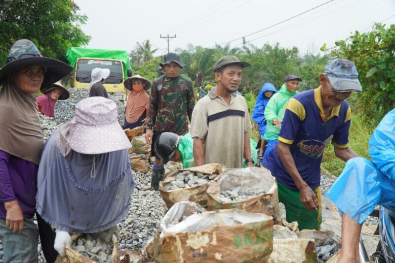 Tetap Semangat Satgas TMMD Ke 126 Kodim 1208/Sambas Bersama Warga Siapkan Batu Untuk Rabat Beton