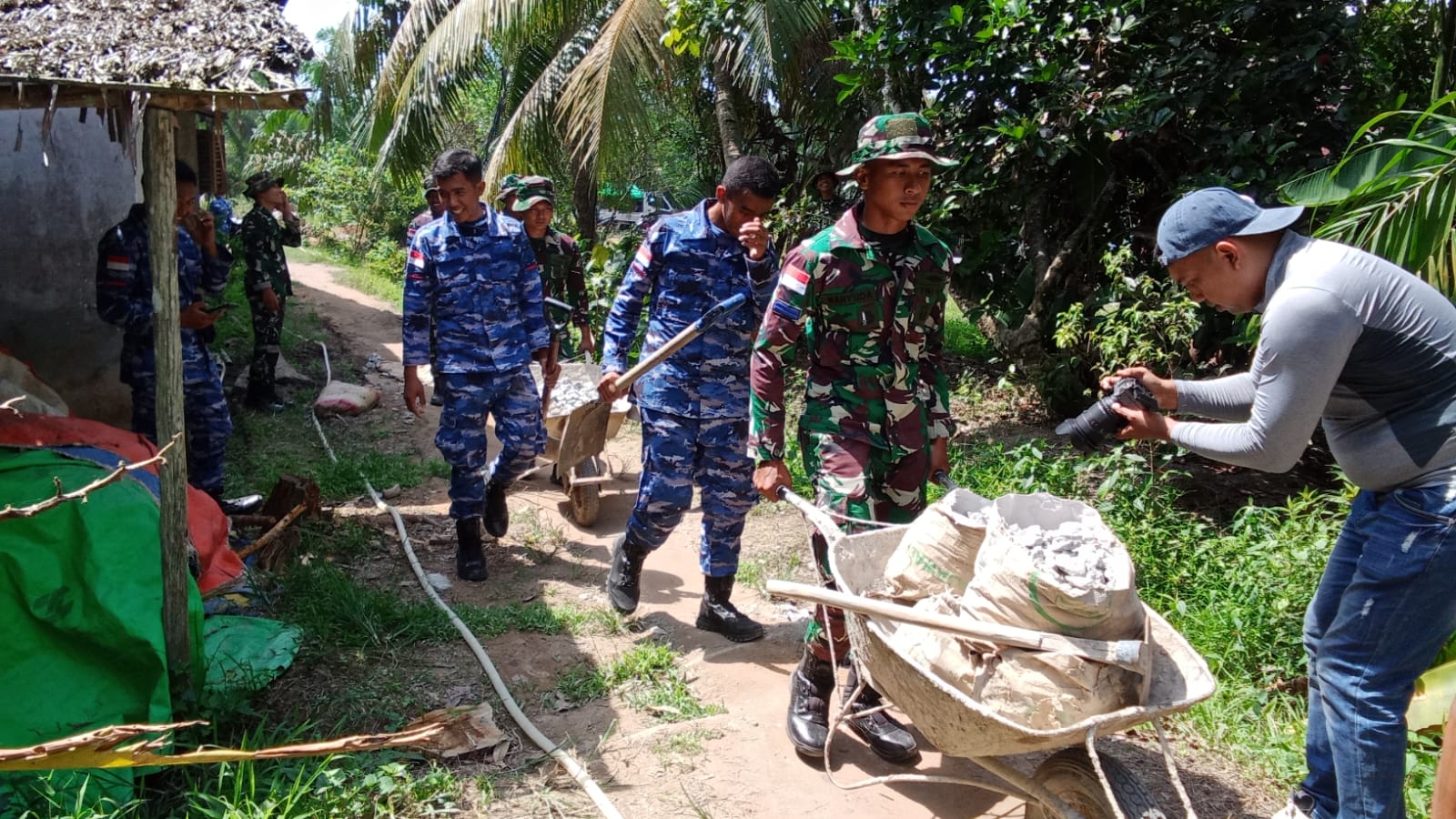 Satgas TMMD ke-126 Kodim 1208/Sambas Bersama Warga Pindahkan Batu Material Rabat Beton ke Lokasi Sasaran