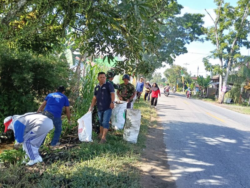 Babinsa Sungai Rambah Ajak Warga Gelar Karya Bakti Bersihkan Sampah di Kiri Kanan Jalan Raya Wilayah Binaan.