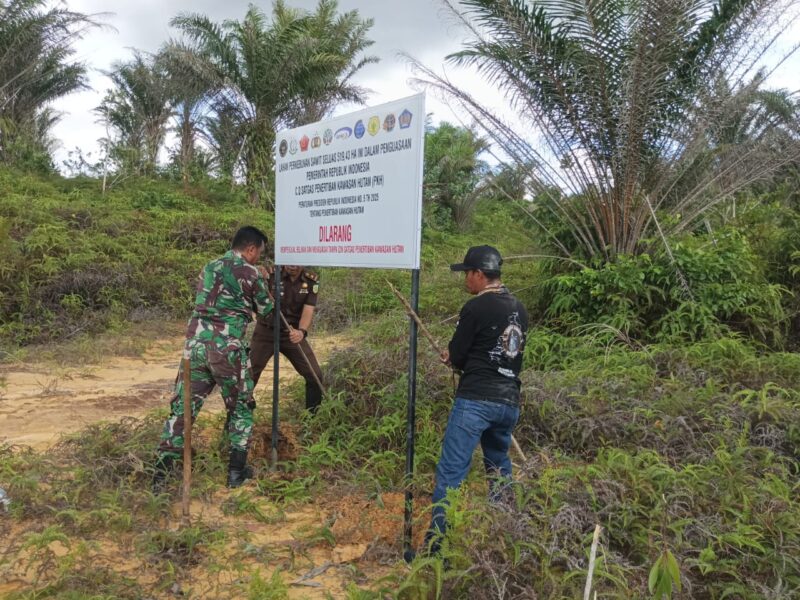 Anggota Koramil 02/Sejangkung Bersama Dinas Terkait Pasang Spanduk Penertiban Kawasan Hutan di Wilayah Binaan